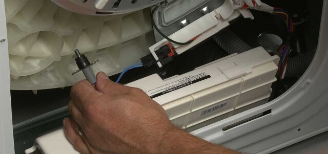 Мастер тестирует датчик температуры в стиральной машине